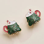 Pair of Christmas Tree Mug stud earrings with glittery green enamel, marshmallow topping, and candy cane accents.